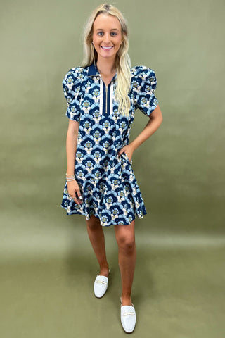 Woman wearing a blue floral dress against a green background