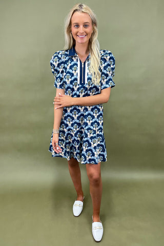 Woman wearing a blue floral dress against a green background