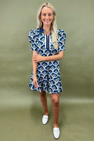 Woman wearing a blue floral dress against a green background