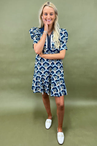 Woman wearing a blue floral dress against a green background