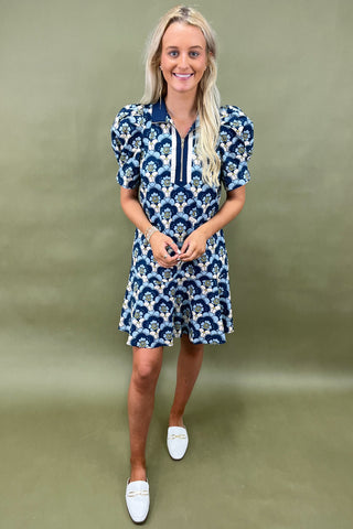 Woman wearing a blue floral dress against a green background