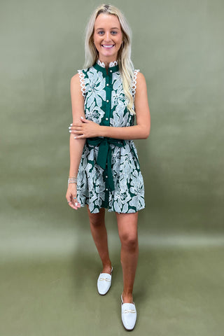 Woman wearing a green and white floral dress against a green background