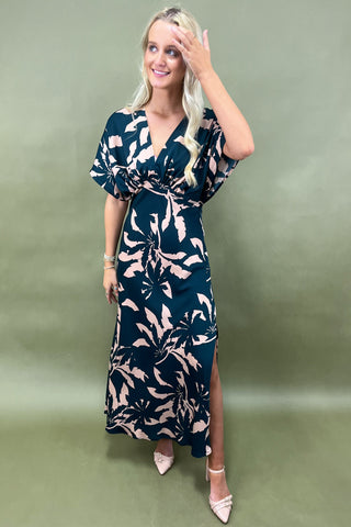Woman wearing a floral dress against a green background