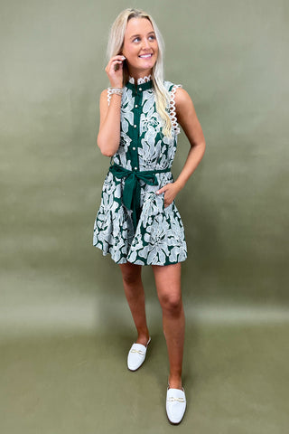 Woman wearing a green floral dress against a green background