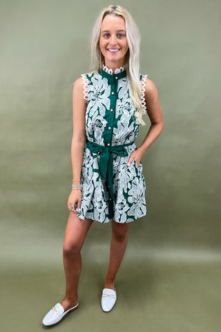 Woman wearing a green and white floral dress against a green background