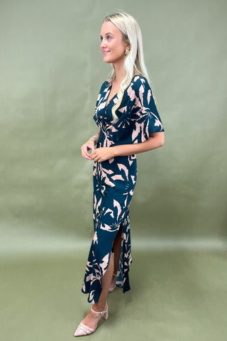 Woman wearing a blue floral dress on a green background