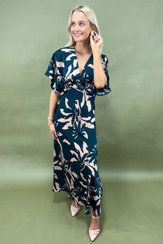 Woman wearing a floral dress against a green background