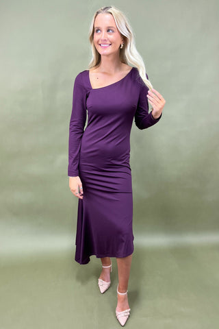 Woman wearing a purple dress against a green background