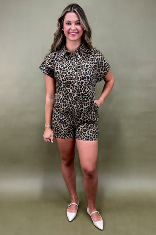 Woman wearing a leopard print romper against a plain background