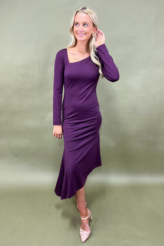 Woman wearing a purple dress against a plain background