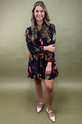 Woman wearing a patterned dress against a plain background