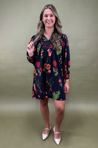 Woman wearing a floral dress against a plain background