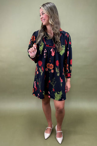 Woman wearing a floral dress against a plain background