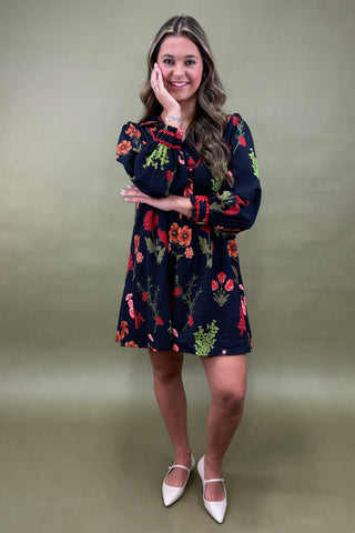 Woman wearing a floral dress against a plain background