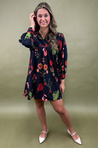 Woman wearing a dark floral dress on a green background