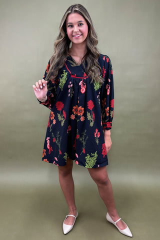 Woman wearing a floral dress against a plain background