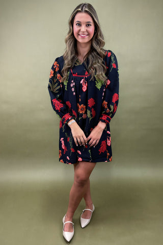 Woman wearing a dark floral dress on a green background
