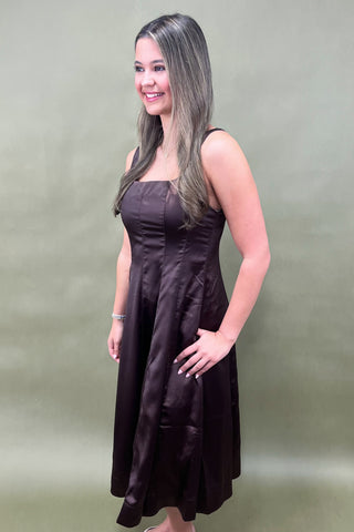 Woman wearing a black dress against a plain background
