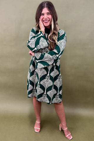 Woman wearing a green and white patterned dress against a green background