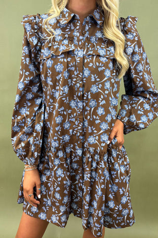 Woman wearing a floral dress with long sleeves on a green background