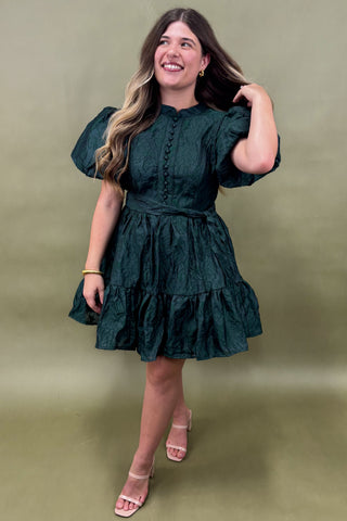 Woman wearing a green dress against an olive green background