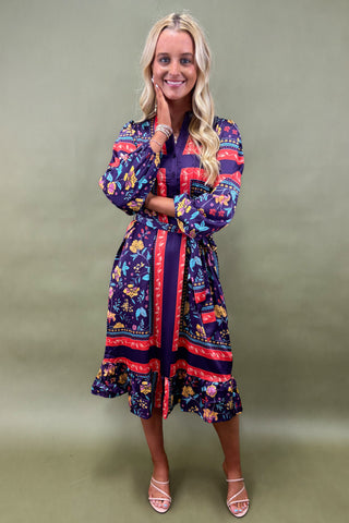 Woman wearing a colorful patterned dress against a green background