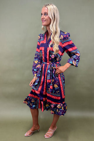Woman wearing a colorful patterned dress against a green background