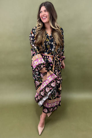 Woman wearing a patterned dress against a green background