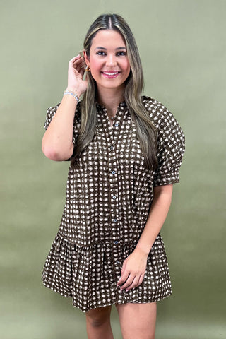 Woman wearing a patterned dress against a green background