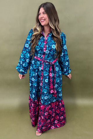 Woman wearing a blue and pink floral dress against a green background