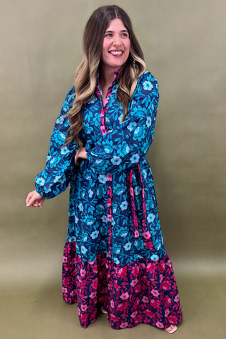 Woman wearing a blue and pink floral dress against a beige background