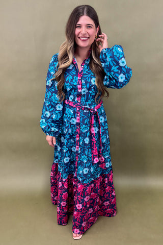 Woman wearing a blue and pink floral dress against a beige background