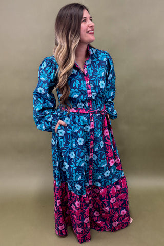 Woman wearing a blue and pink floral dress against a beige background
