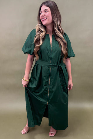 Woman wearing a green dress against a beige background
