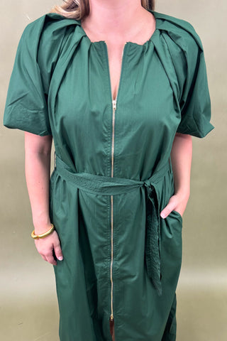 Person wearing a green jumpsuit with a plain background