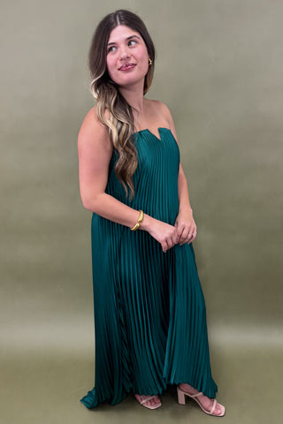 Woman wearing a teal strapless dress against a green background