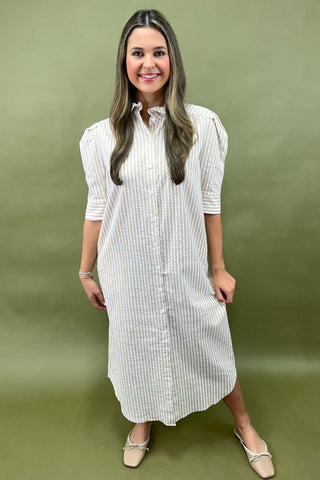 Woman wearing a white checkered dress against a green background