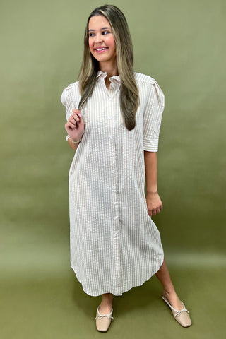 Woman wearing a white checkered dress against a green background