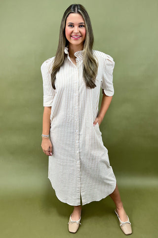 Woman wearing a white checkered dress against a green background