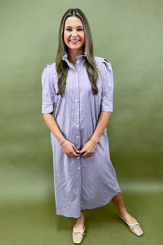 Woman wearing a striped dress against a green background