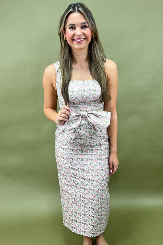 Woman wearing a floral dress against a green background
