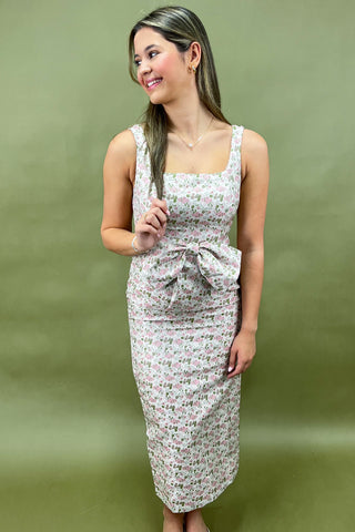Woman wearing a floral dress against a green background