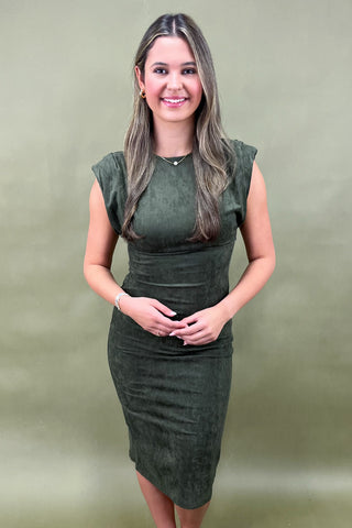 Woman wearing a green dress against a plain background