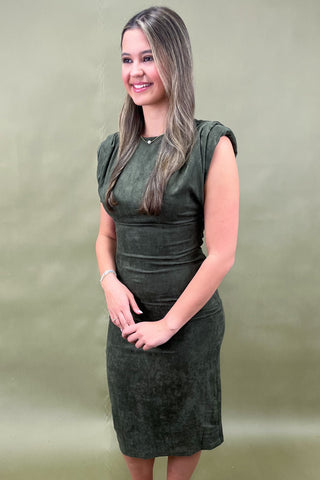 Woman wearing a green dress against a plain background