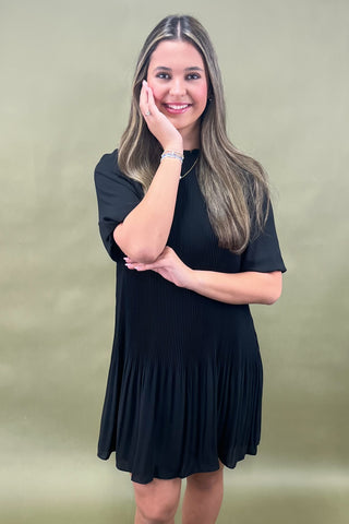 Woman wearing a black dress against a green background