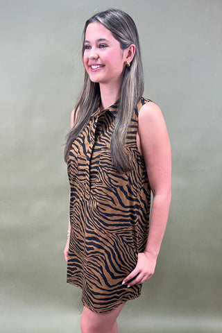 Woman wearing a zebra print dress against a plain background