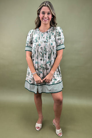 Woman wearing a floral dress against a green background