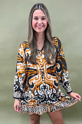 Woman wearing a patterned dress against a green background