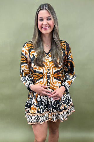 Woman wearing a patterned dress against a green background
