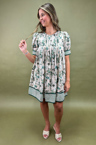 Woman wearing a floral dress against a green background